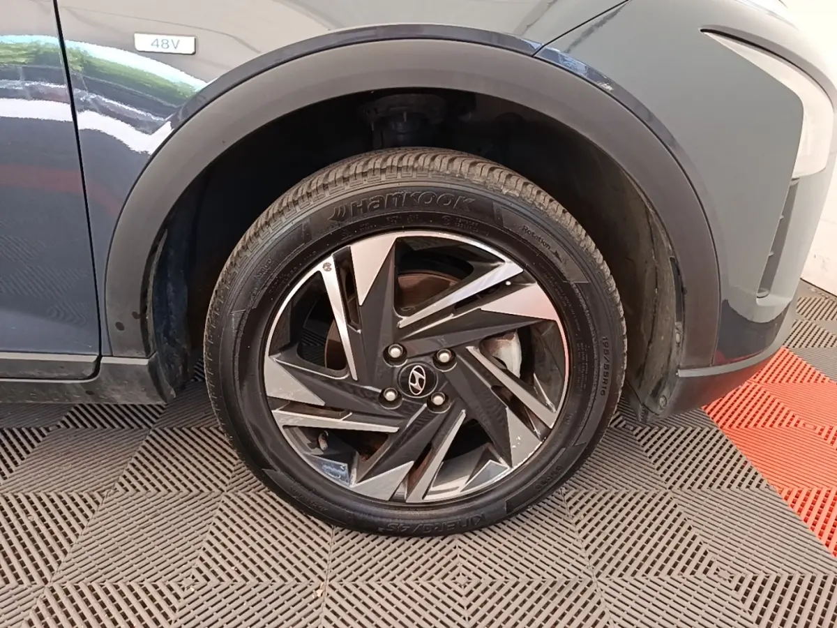 Gros plan sur la roue avant droite gris foncé du Hyundai Bayon 2023 avec jante alliage noire et argentée.