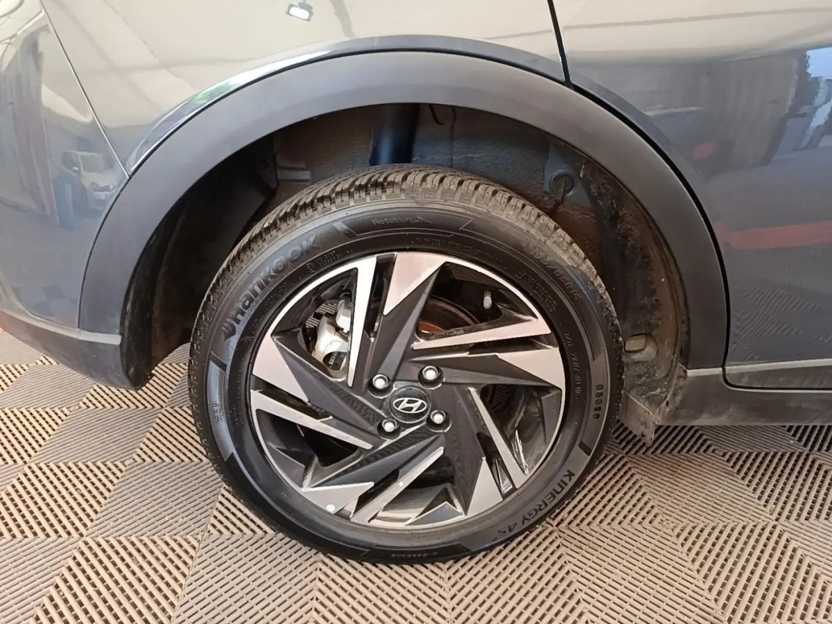 Gros plan sur la roue arrière droite gris foncé d’une Hyundai Bayon 2023 avec jante alliage au design géométrique.