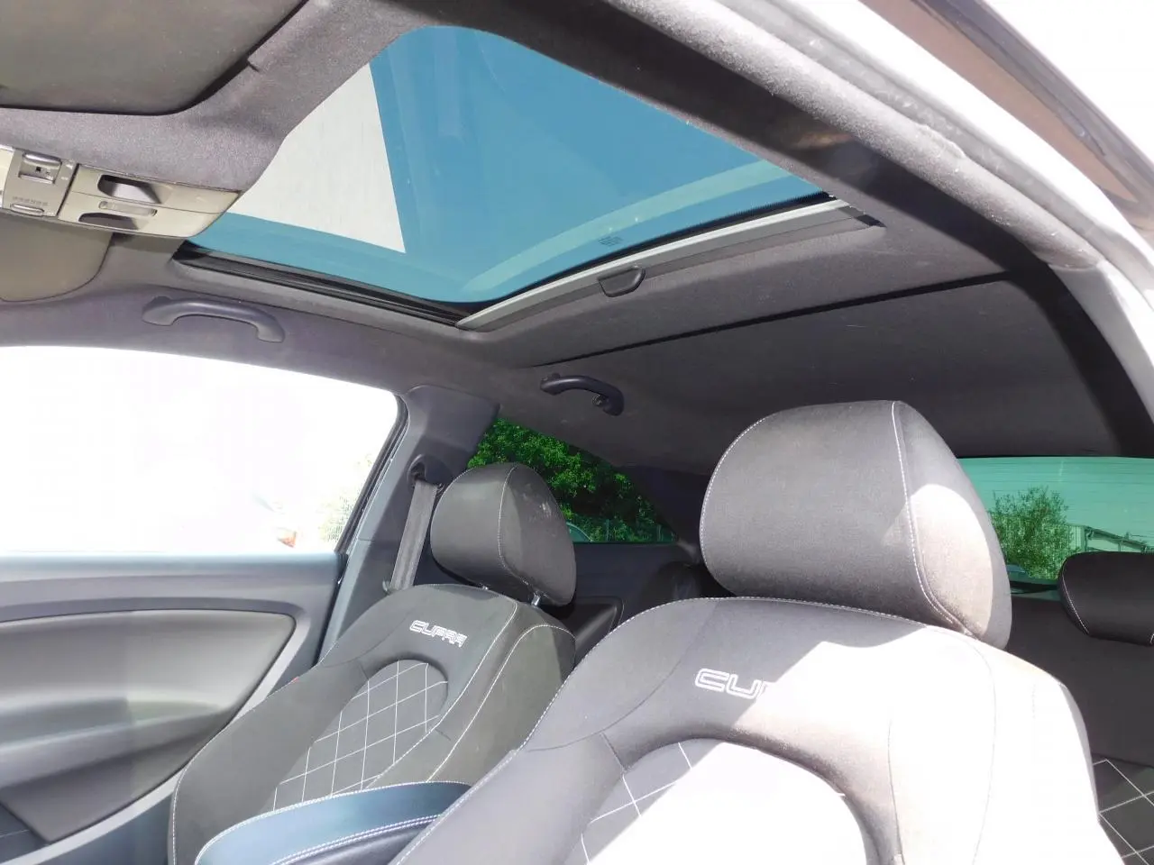 Intérieur noir de la SEAT Ibiza Cupra 2011 vu côté conducteur, avec toit ouvrant transparent et sièges sport Cupra.