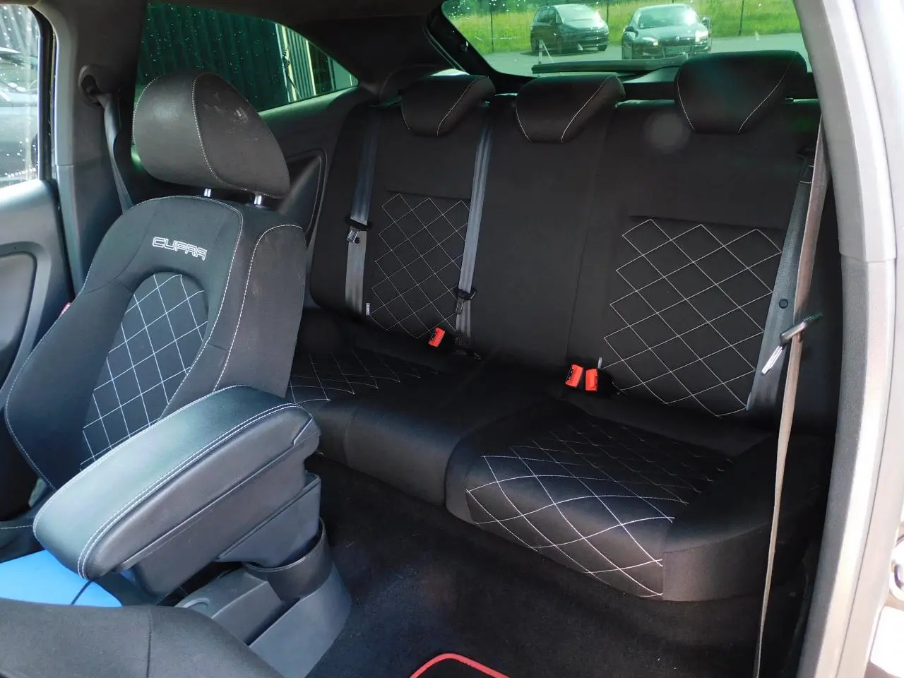 Vue intérieure arrière de la SEAT Ibiza Cupra noire, sièges sport avec surpiqûres et logo Cupra brodé.