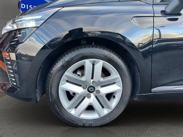 Vue de profil côté gauche d'une Renault Clio V noire, mettant en valeur l'avant avec ses phares LED distinctifs.