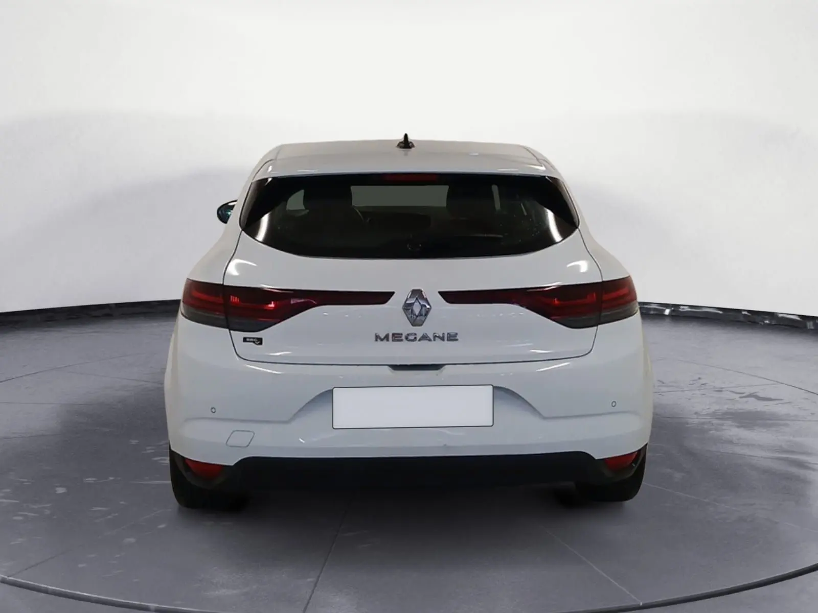 Vue arrière d'une Renault Mégane IV blanche de 2020 avec feux allongés et logo central visible.