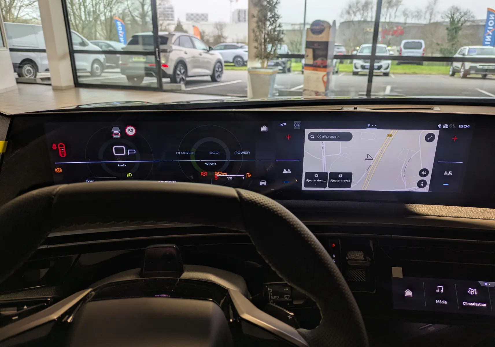 Vue intérieure du tableau de bord numérique et écran tactile du Peugeot 3008 gris titanium, avec volant en premier plan.