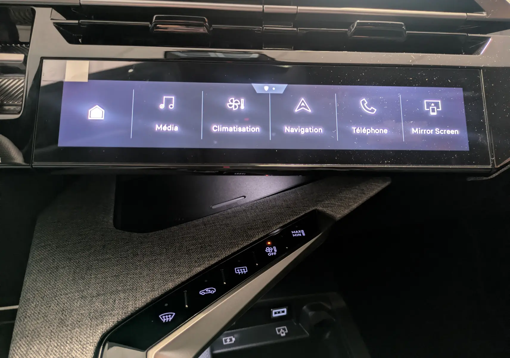 Vue rapprochée de l’écran tactile central et de la console en tissu gris du Peugeot 3008 gris titanium, affichant les menus multimédia et climatisation.