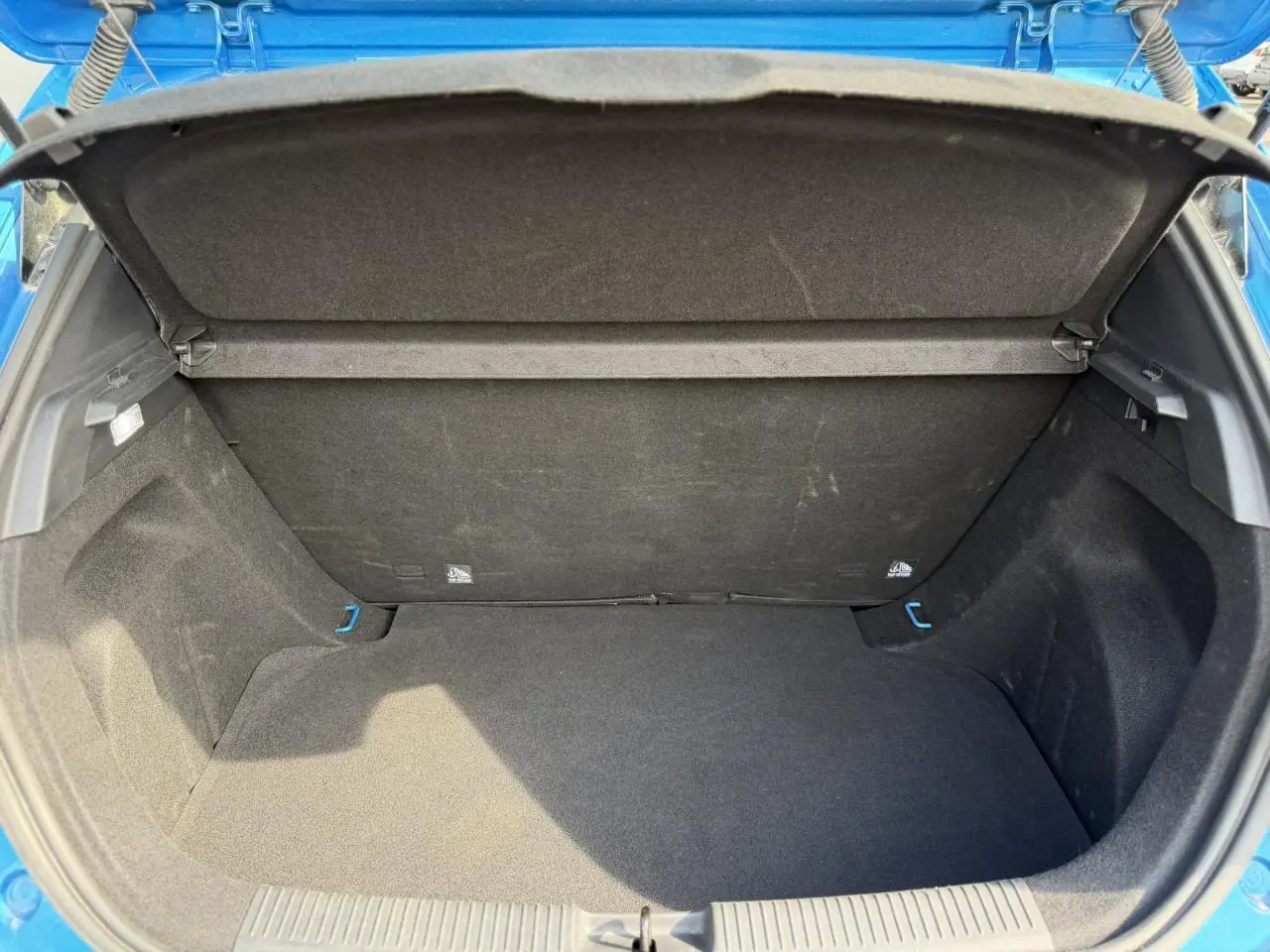 Coffre ouvert vu de l'arrière d'une MG3 1.5 Hybrid+ 195 Comfort bleu Como, intérieur noir et tapis plat.