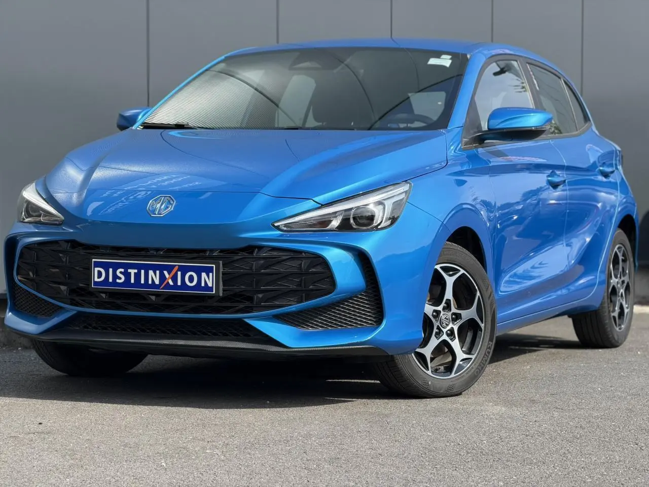 MG3 1.5 Hybrid+ 2025 en bleu Como, vue 3/4 avant droit avec calandre noire et jantes alliage 16 pouces.