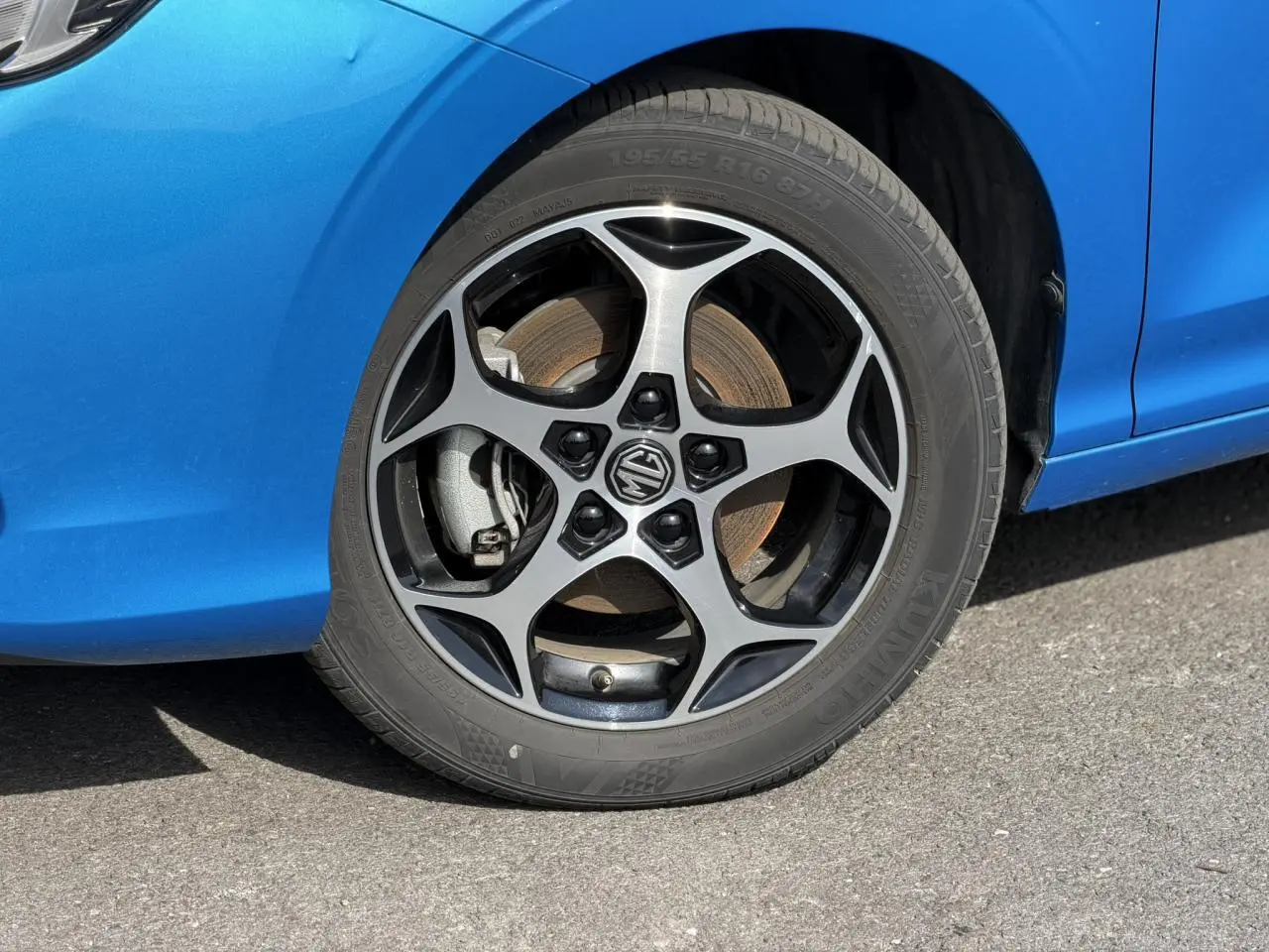 Gros plan sur la roue avant gauche avec jante alliage 16'' et carrosserie bleu Como d'une MG3 2025.