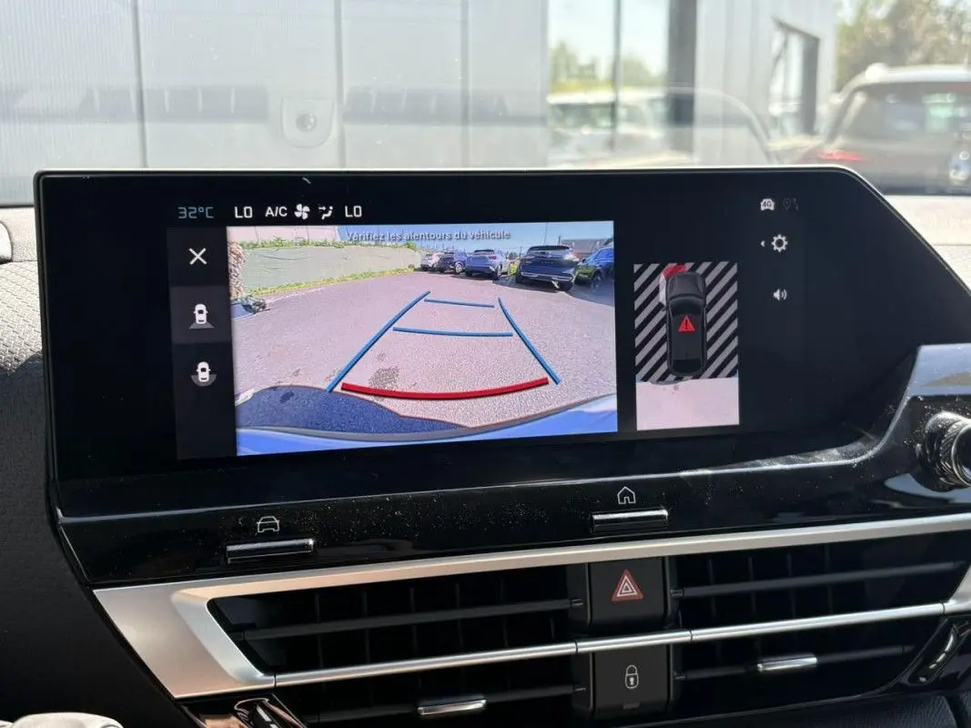 Écran central de la Citroën C4 Hybrid 145 blanc montrant la caméra de recul avec guidage et vue périphérique.