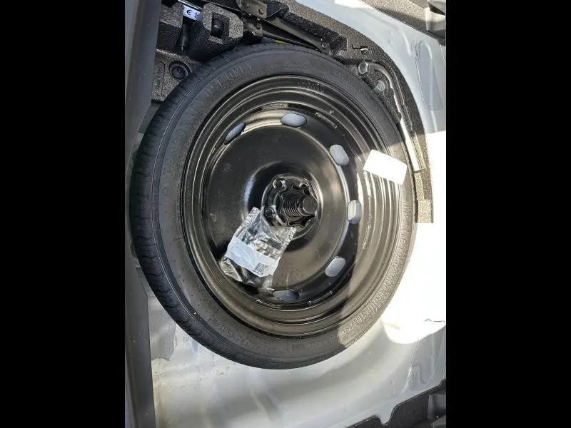 Roue de secours noire en acier dans le coffre d'un CUPRA Formentor blanc Nevada métallisé 2025, vue plongeante.