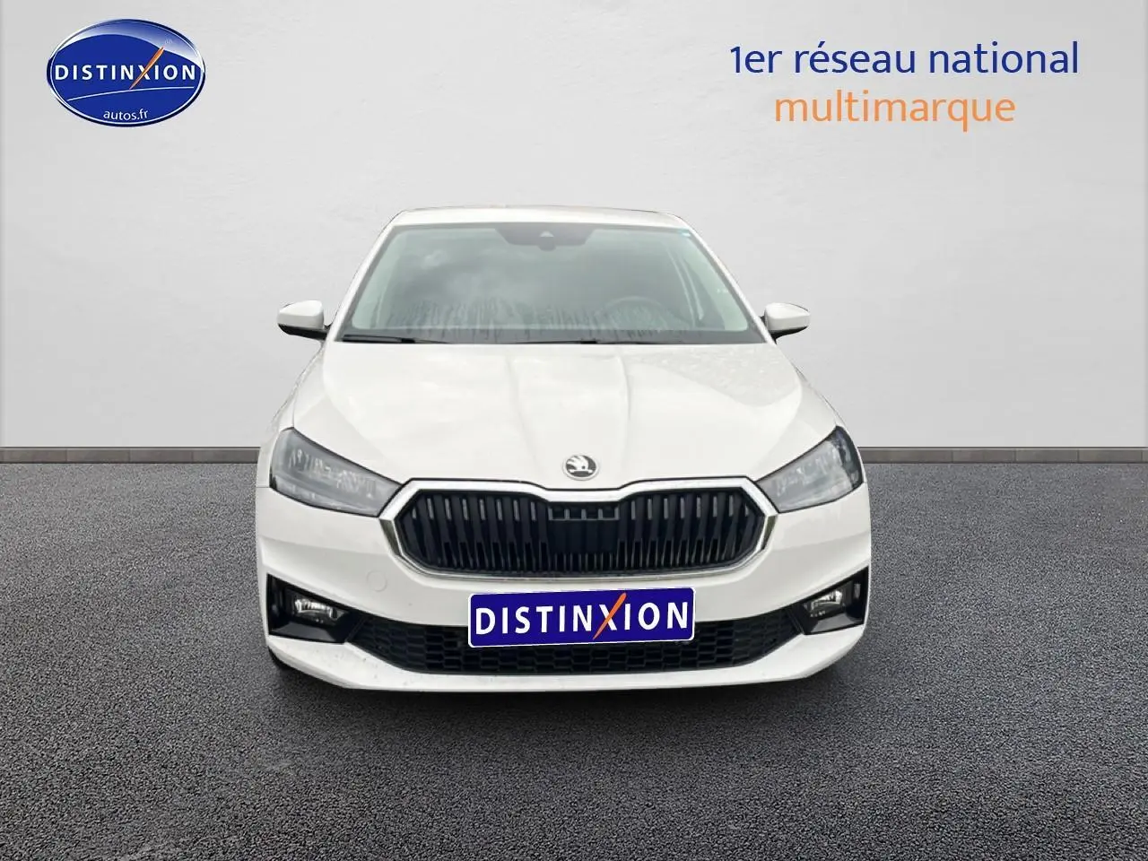 Vue frontale d'une Skoda Fabia blanche 2025 avec calandre noire et phares LED allumés.