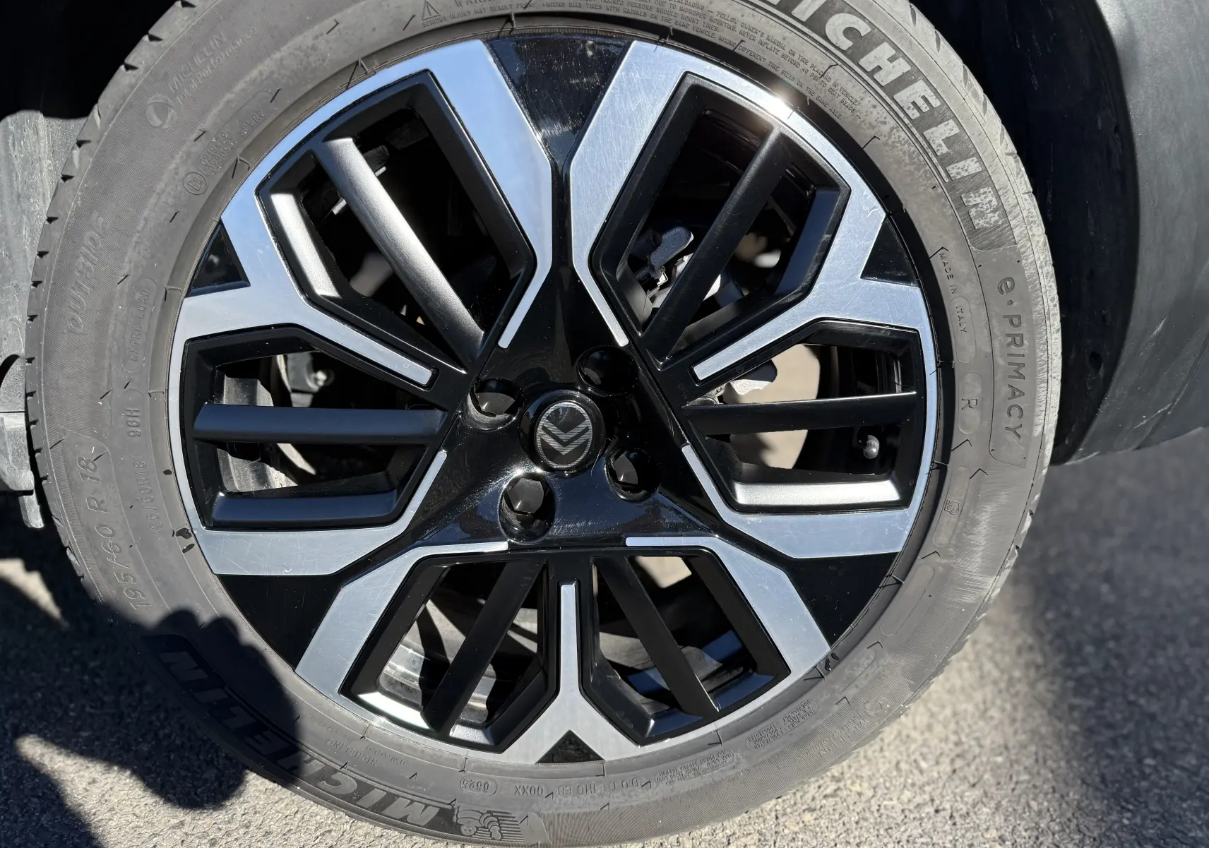 Gros plan sur la jante noire et argentée au design géométrique du Citroën C4 Hybrid 2025 en blanc Okenite.
