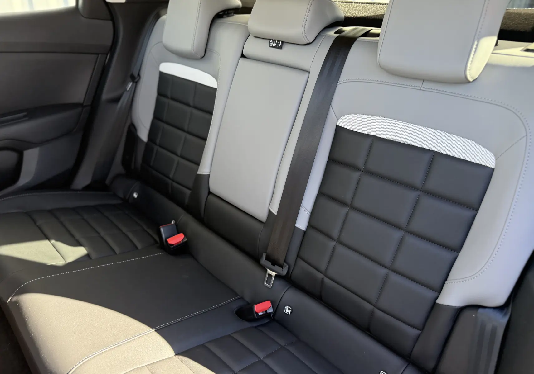 Vue intérieure de la banquette arrière bicolore noire et grise du Citroën C4 Hybrid 145 CH Max 2025.
