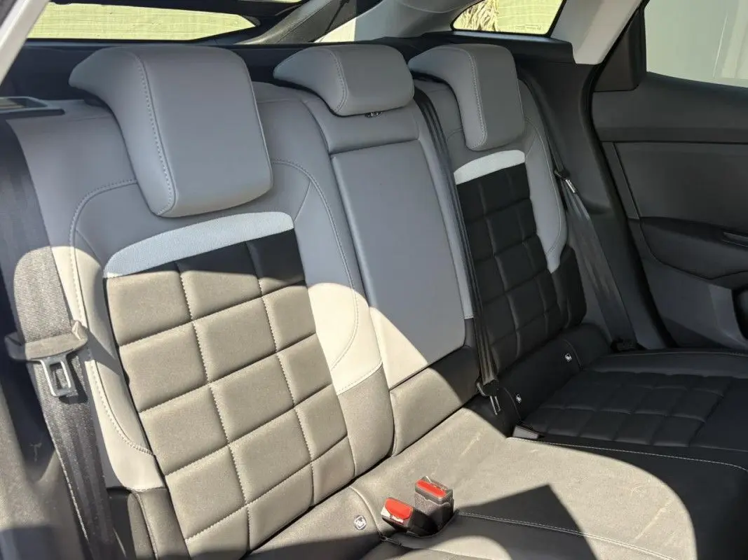 Vue intérieure côté conducteur de la Citroën C4 Hybrid 145 ch 2025 avec sièges bi-ton gris clair et foncé.