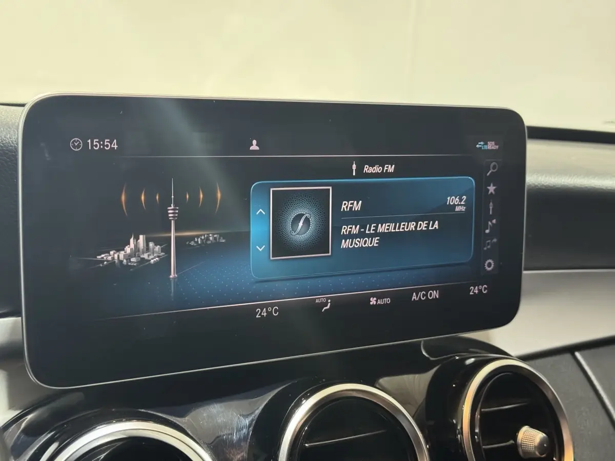 Écran tactile central affichant la radio FM dans l'habitacle d'une Mercedes Classe C Break noire de 2019