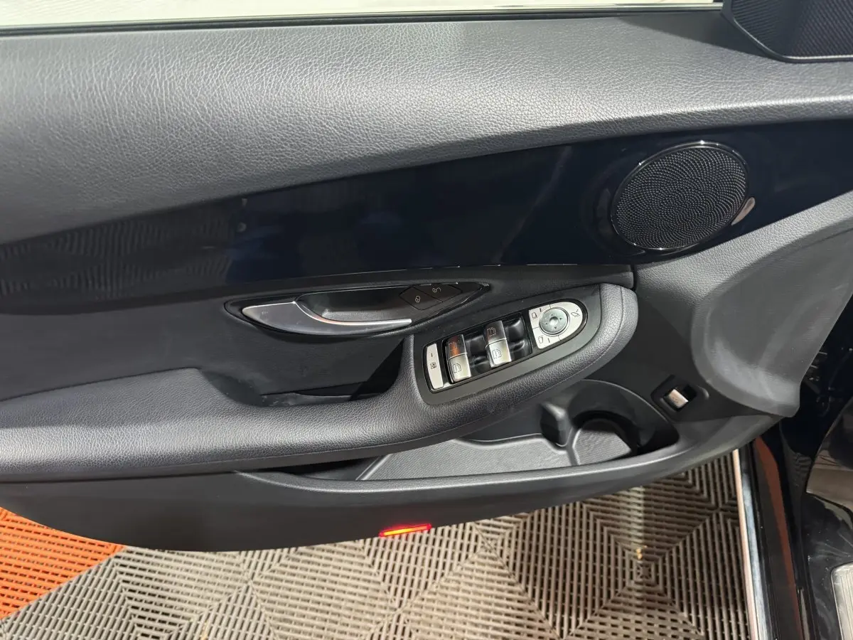 Vue rapprochée de la porte côté conducteur noire du Mercedes Classe C Break C 200 d avec commandes de vitres et haut-parleur intégré.