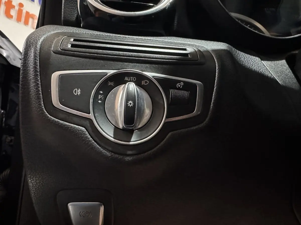 Gros plan sur le bouton de commande des phares dans l'habitacle noir du Mercedes Classe C Break C 200 d Business Line 2019.