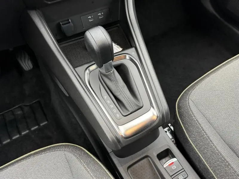 Gros plan sur la console centrale du Renault Captur 2025, levier de boîte auto entouré de garnitures noires et argentées.