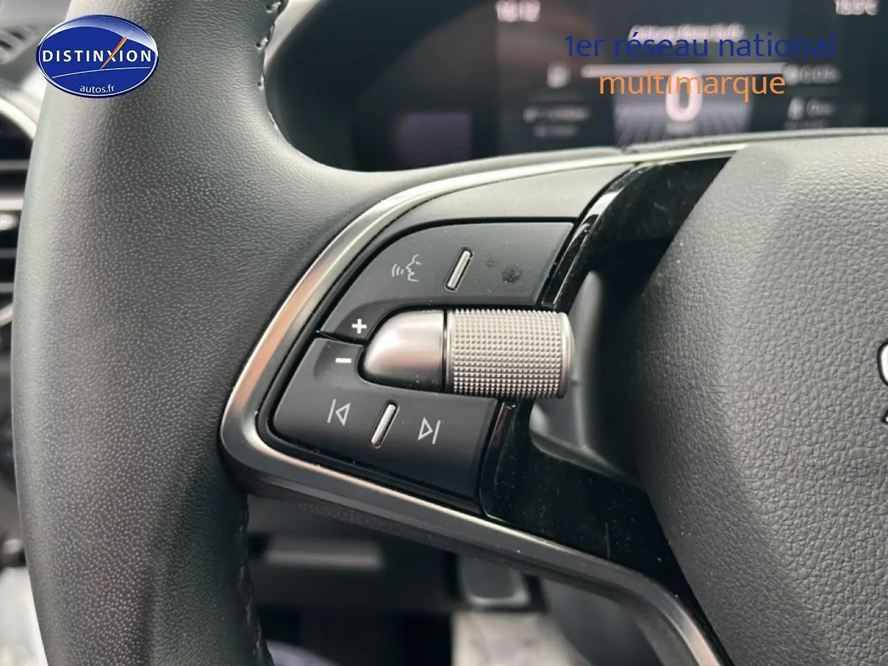 Gros plan sur les commandes audio et de volume au volant cuir noir de la Skoda Fabia blanche 2025.