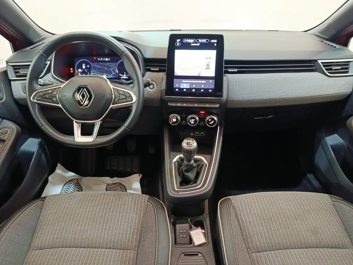 Vue intérieure avant de la Renault Clio Techno TCe 90 2024, volant multifonctions, écran tactile vertical et levier de vitesse manuel.