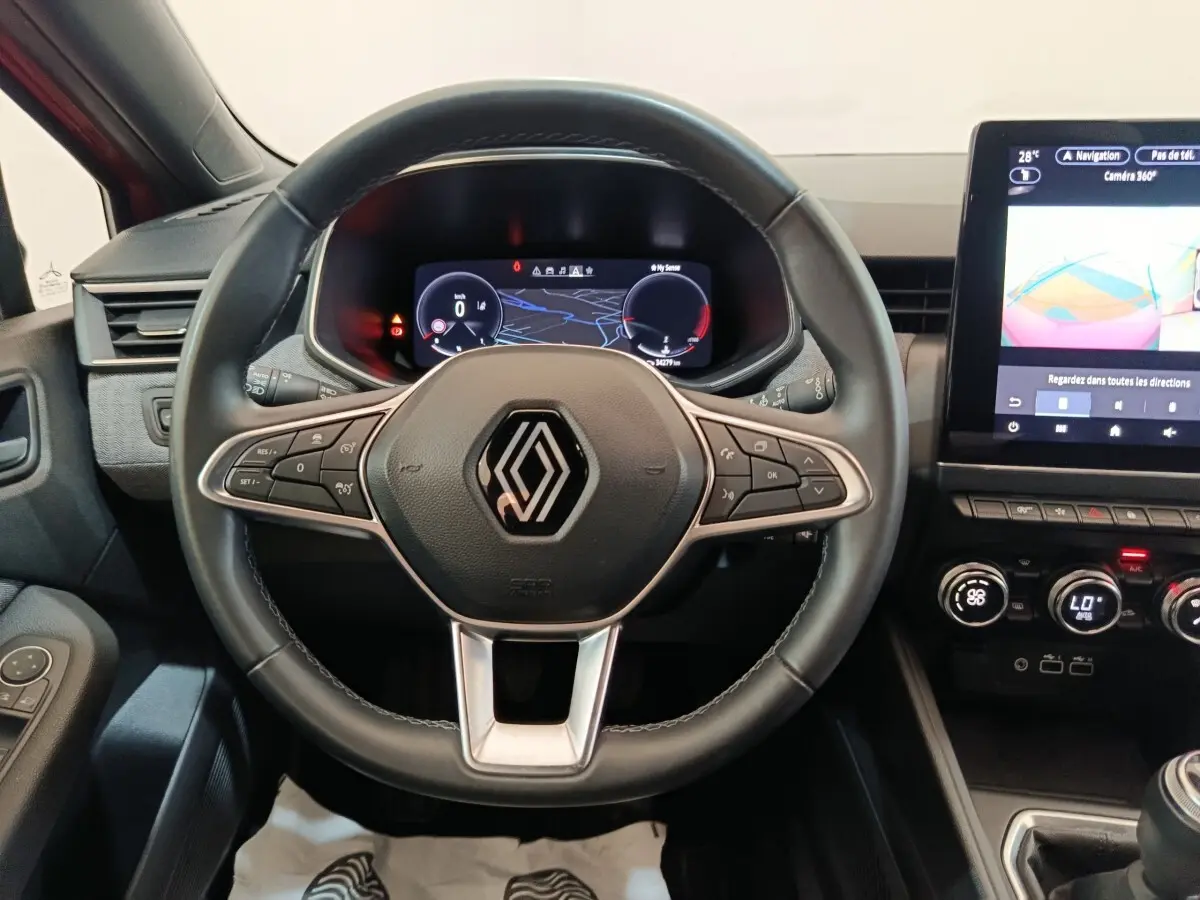 Vue rapprochée du volant cuir de la Renault Clio Techno TCe 90 2024 avec tableau de bord numérique et écran tactile central.