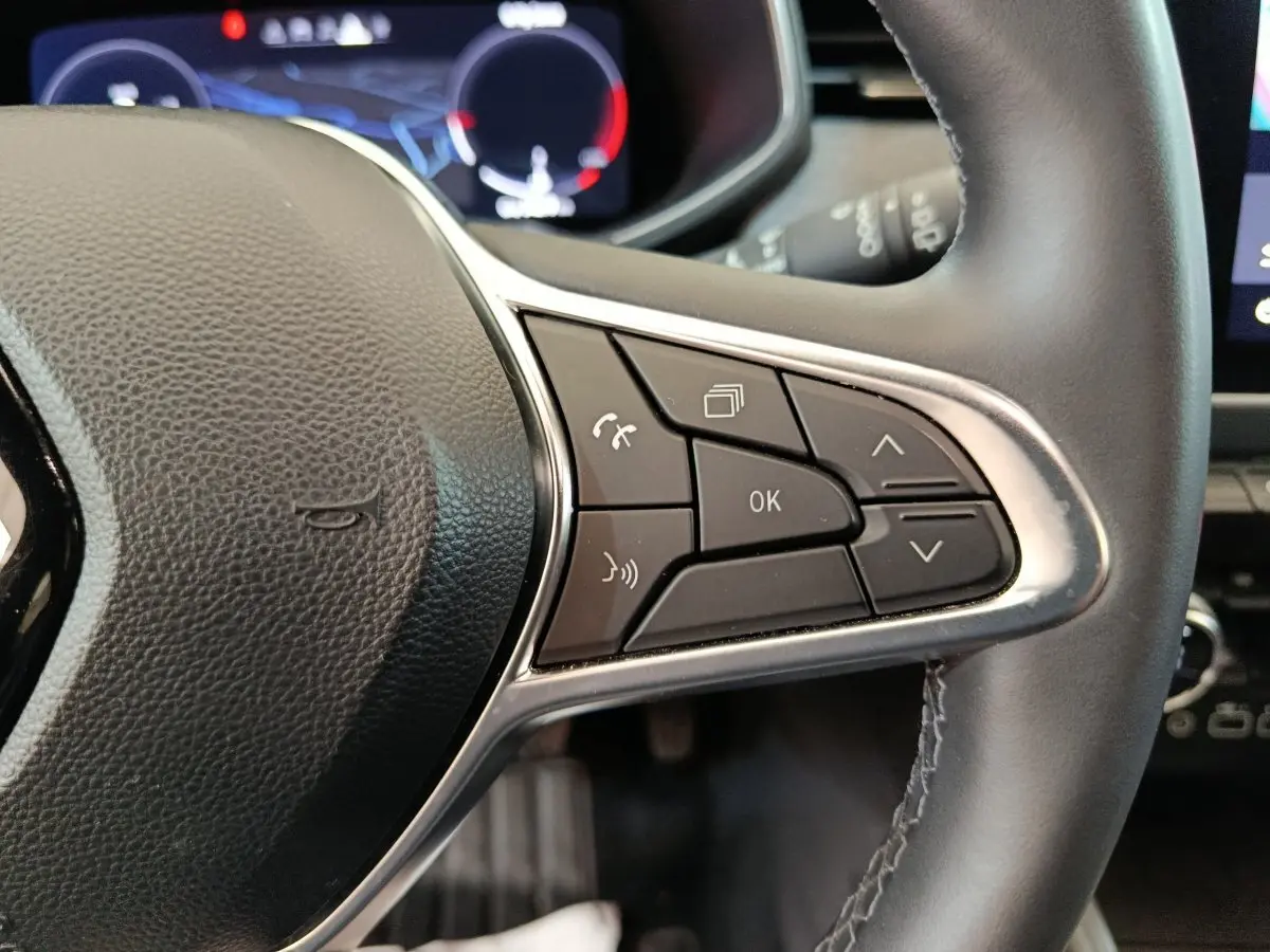Gros plan sur le côté droit du volant cuir de la Renault Clio Techno TCe 90 2024 avec commandes multifonctions.