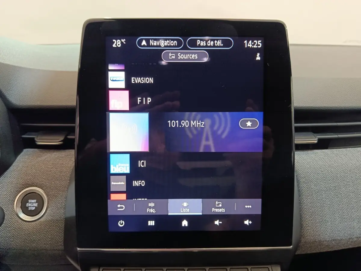 Écran tactile central de la Renault Clio Techno TCe 90 2024 affichant la radio FM et bouton démarrage à gauche.