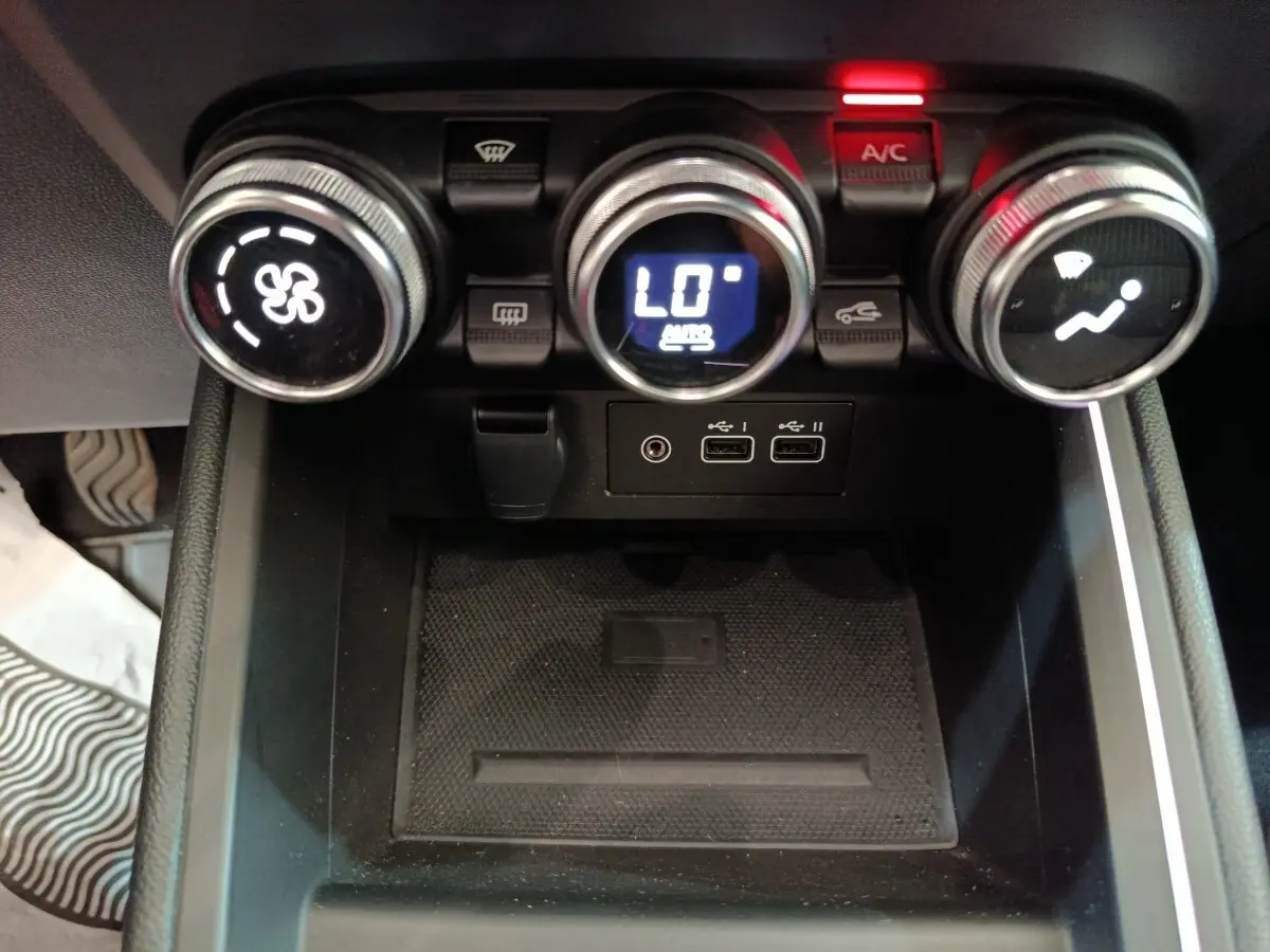 Vue rapprochée des commandes de climatisation et des ports USB du tableau de bord de la Renault Clio Techno TCe 90 2024.