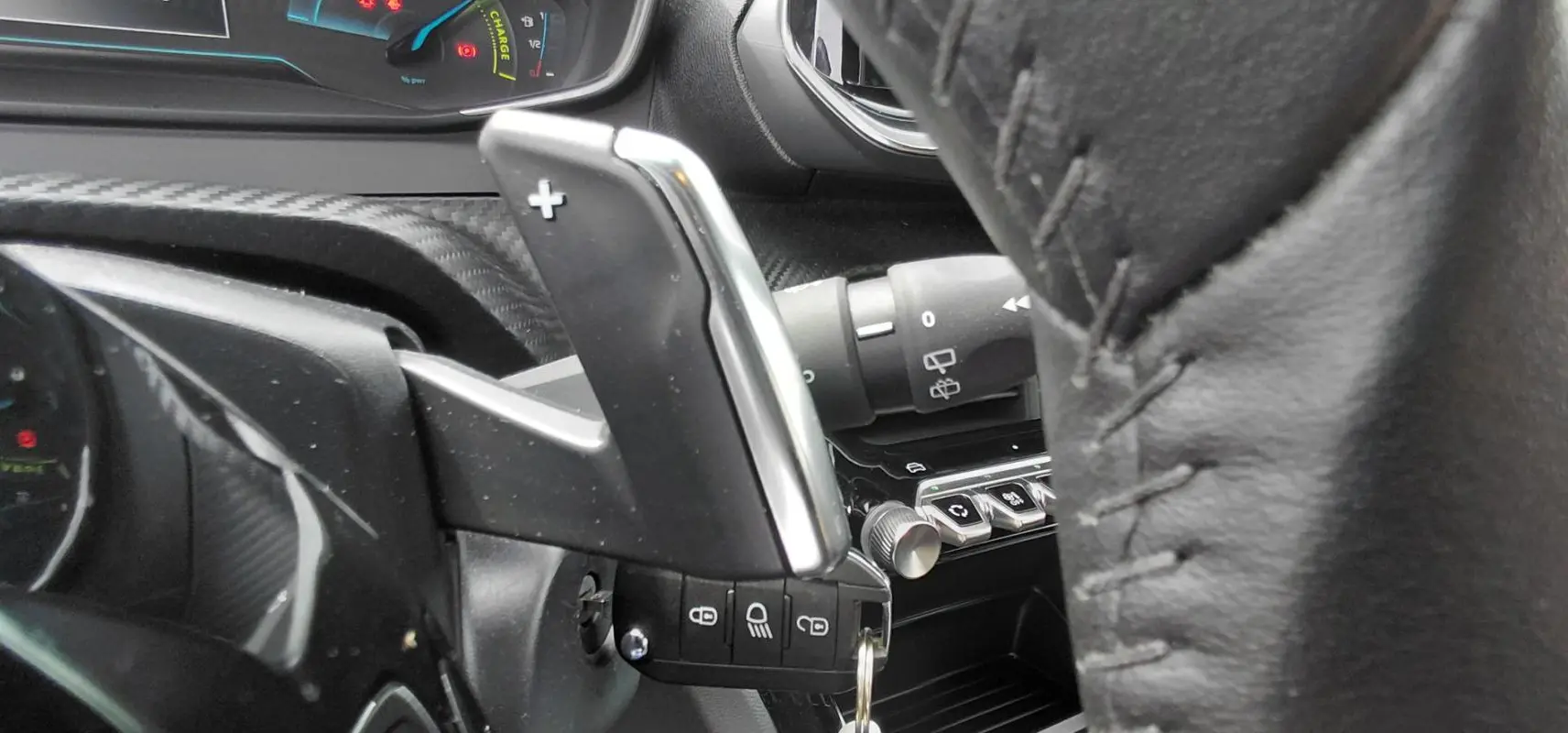 Détail de la palette de changement de vitesse au volant dans l’habitacle noir du Peugeot 2008 Hybrid 145 e-DCS6 Style 2025.