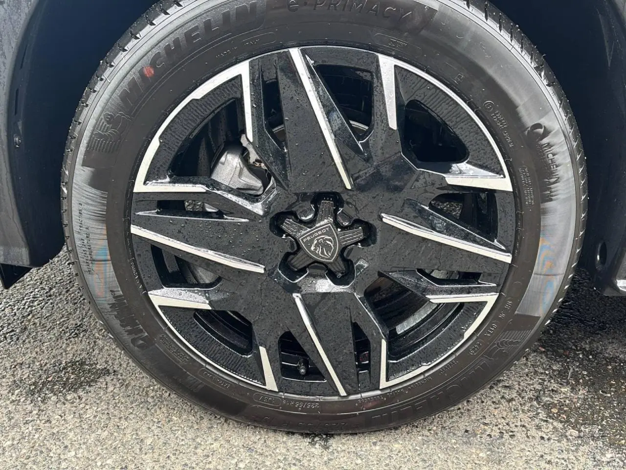 Gros plan sur la jante alliage 19'' diamantée noire et argentée du Peugeot 3008 noir Perla, roue mouillée.