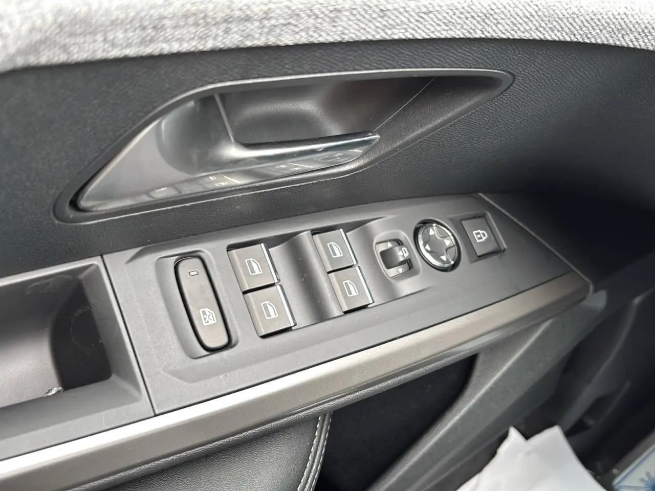 Gros plan sur les commandes de lève-vitres et rétroviseurs côté gauche d’un Peugeot 3008 noir Perla 2026.