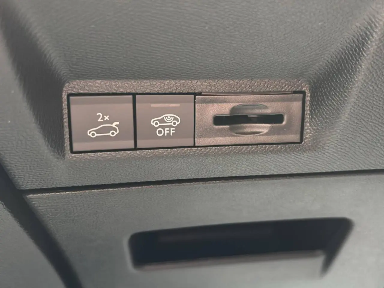 Boutons de commande du hayon électrique et de l'alerte de détection, vue rapprochée de l'intérieur noir du Peugeot 3008 GT hybride.