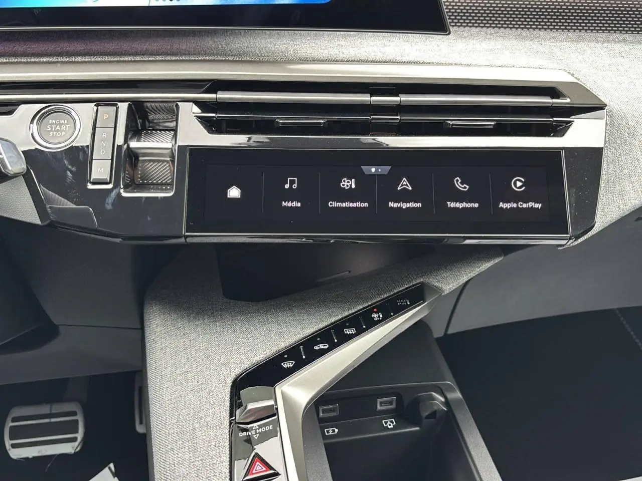 Vue rapprochée de la console centrale du Peugeot 3008 2026, avec écran tactile panoramique et commandes tactiles sur finition tissu gris.