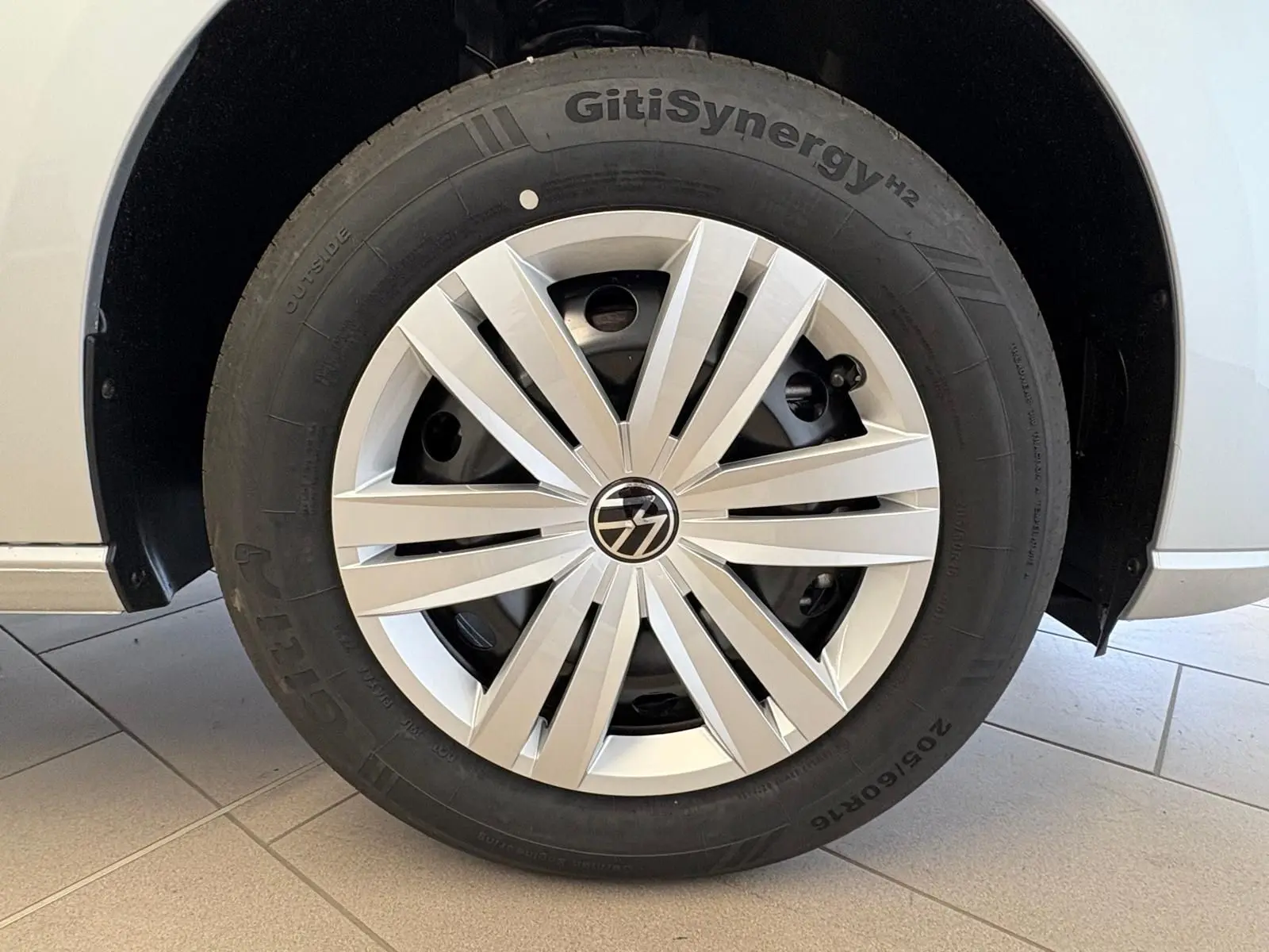 Gros plan sur la roue avant droite du Volkswagen Caddy gris argent 2025, avec jante à enjoliveur moderne.