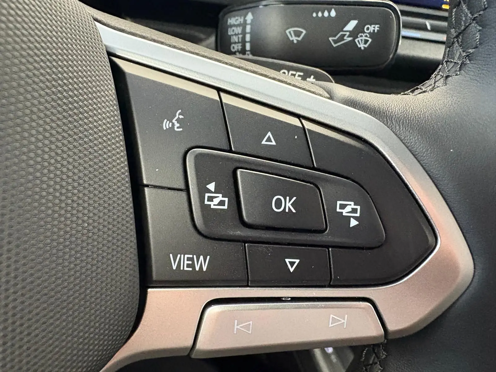 Gros plan sur les commandes multifonctions du volant gris argenté du Volkswagen Caddy 2025, version Business.