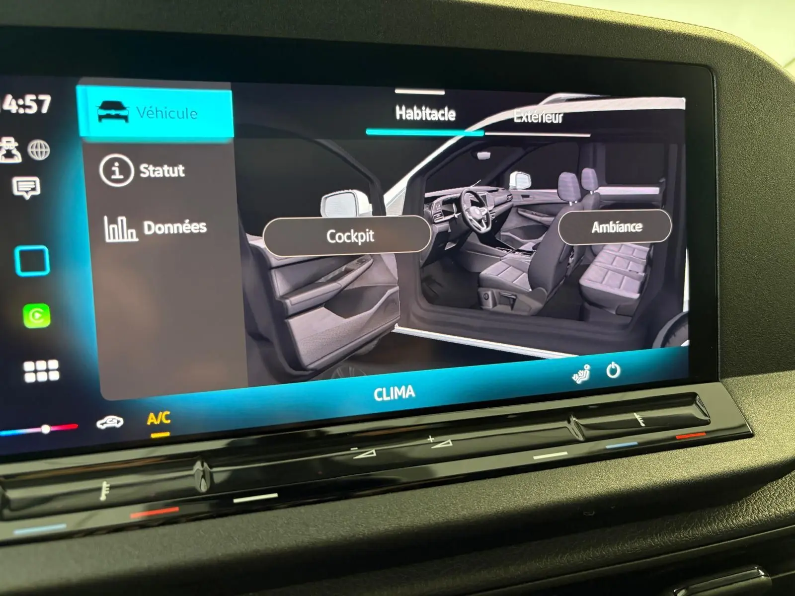 Écran tactile montrant l'intérieur du Volkswagen Caddy 2025, vue côté gauche avec sièges et tableau de bord gris.