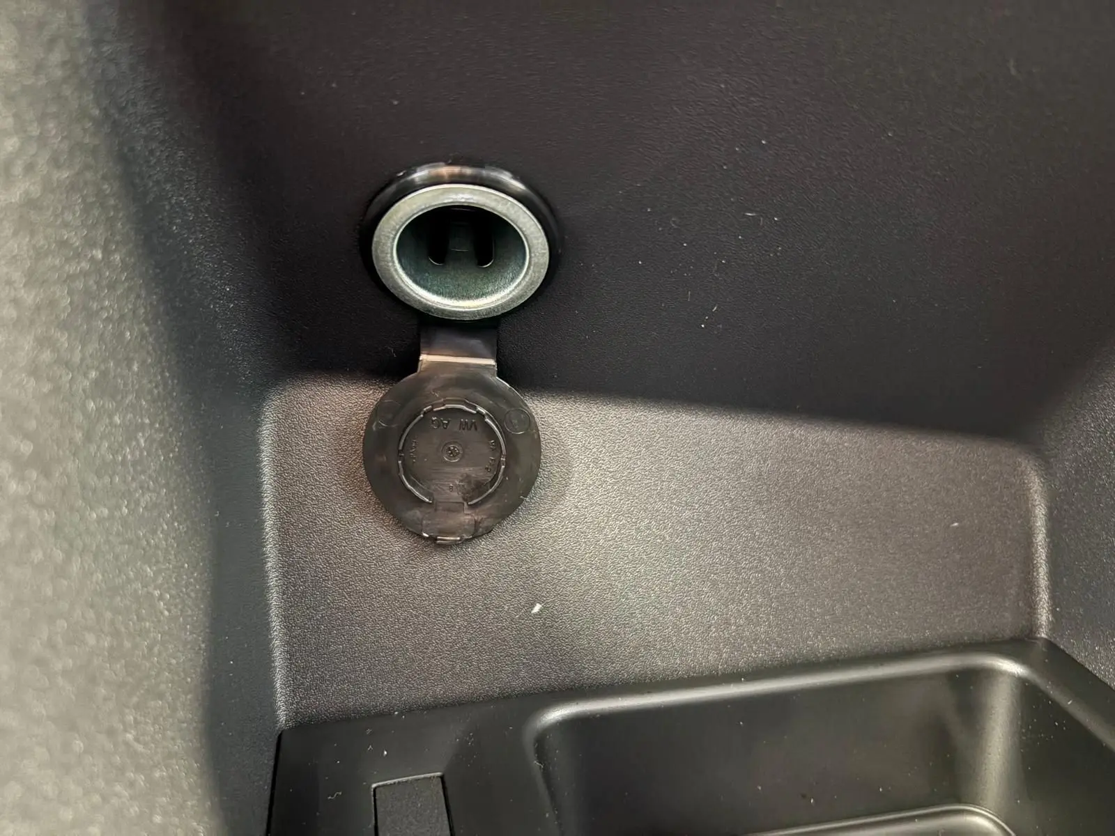 Prise 12V ouverte dans le compartiment de rangement intérieur du Volkswagen Caddy gris argent 2025.