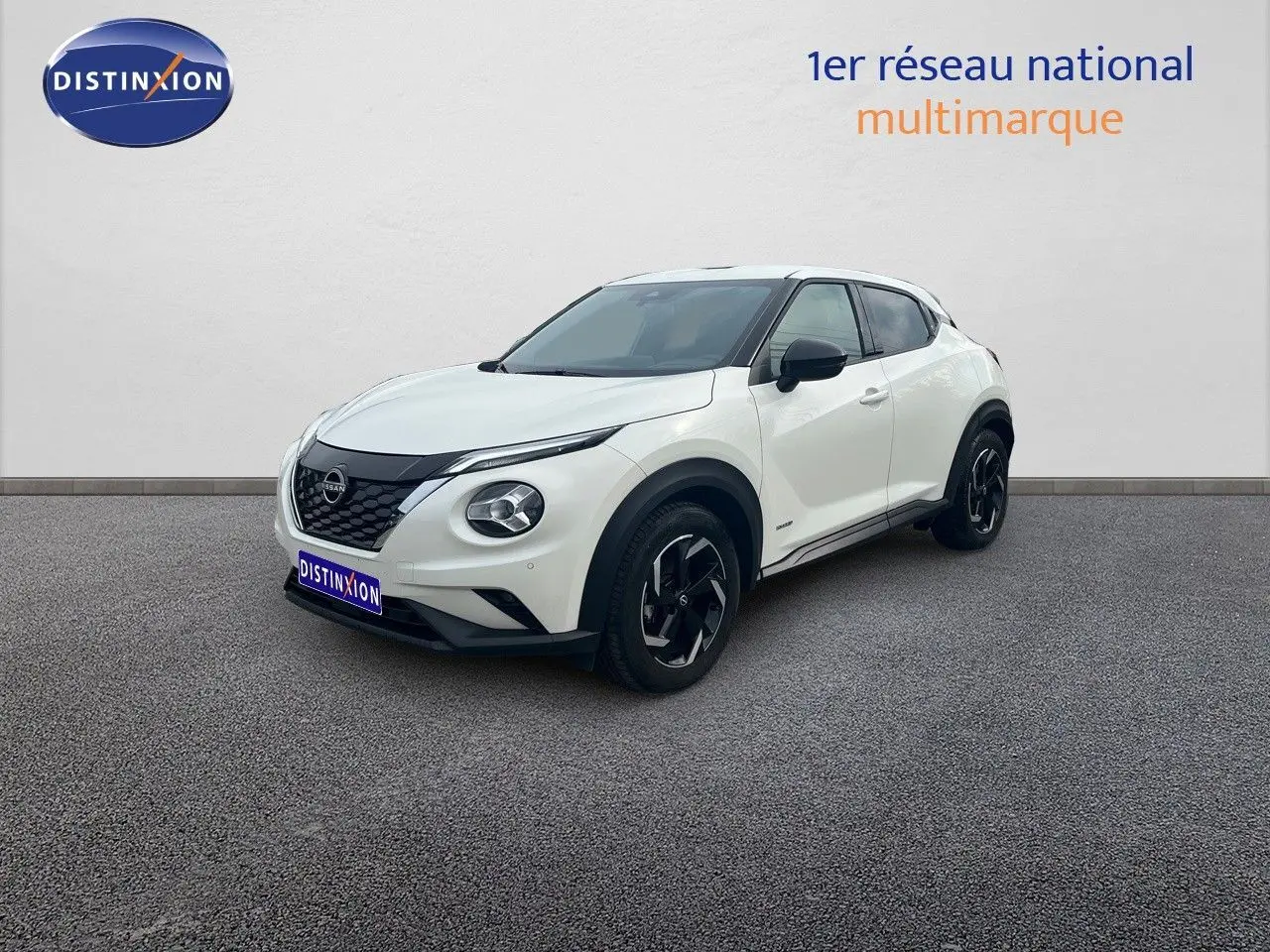 Nissan Juke blanc nacré métal en vue 3/4 avant droit, avec jantes noires et toit contrasté noir.