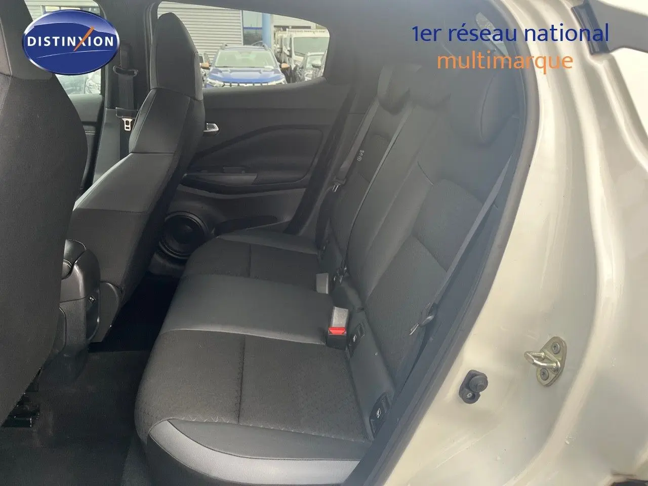 Vue intérieure côté droit montrant la banquette arrière en tissu noir du Nissan Juke blanc nacré 2024.