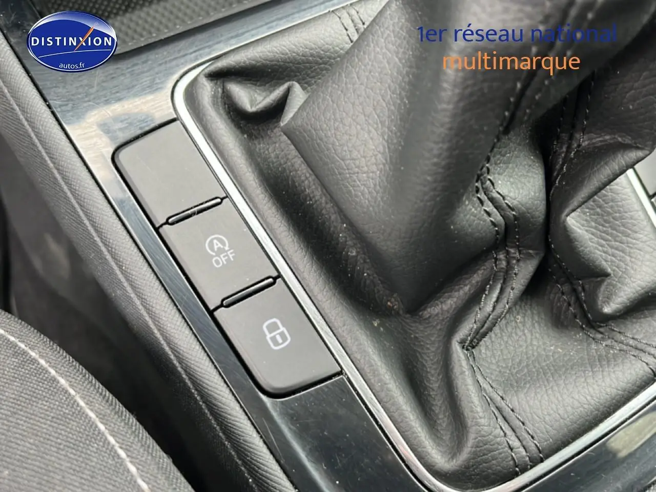 Gros plan sur la console centrale noire avec levier de vitesses cuir et boutons de commande sur Skoda Fabia blanche.