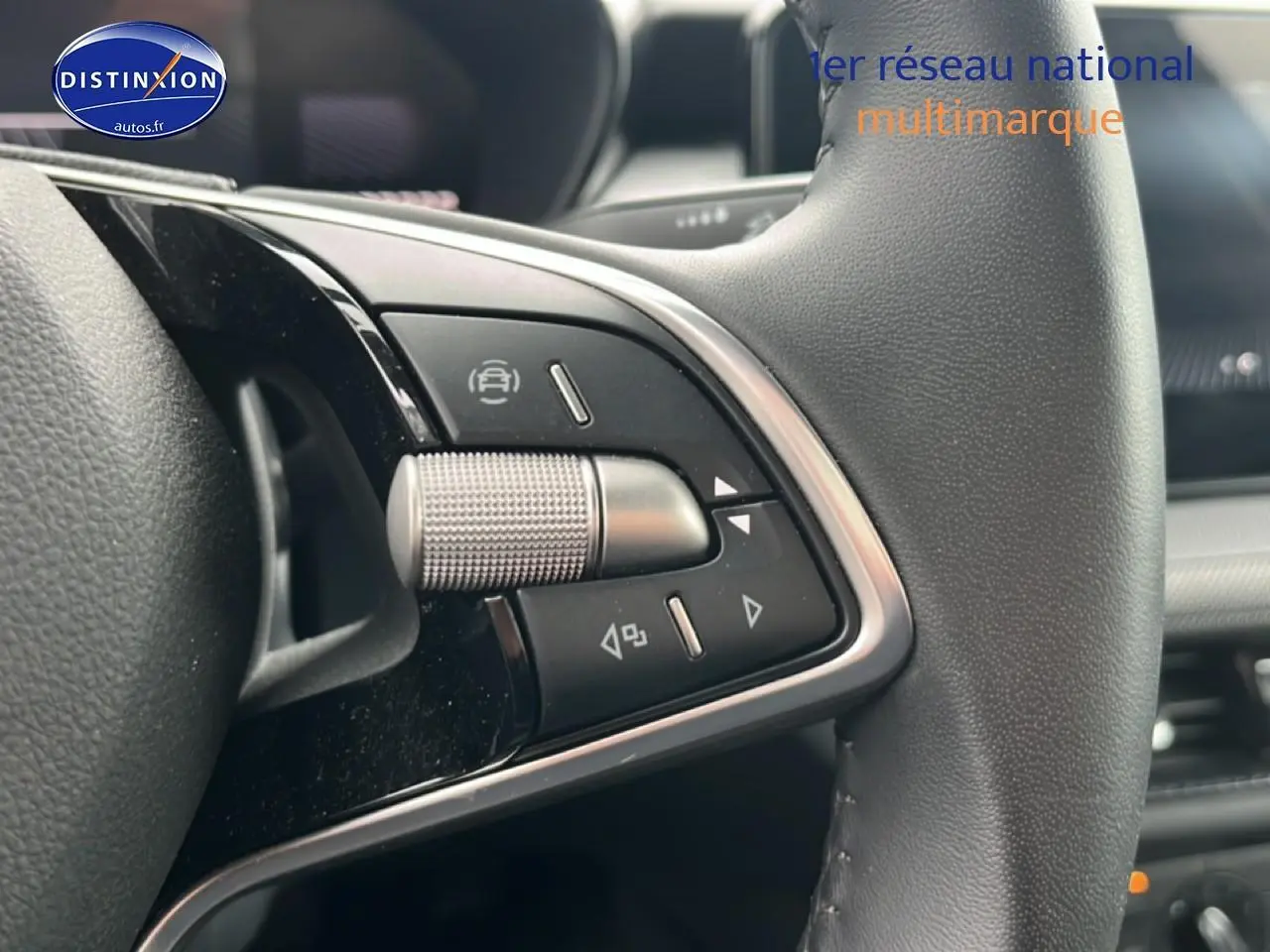 Gros plan sur les commandes multifonctions en aluminium et cuir du volant de la Skoda Fabia blanche 2025.