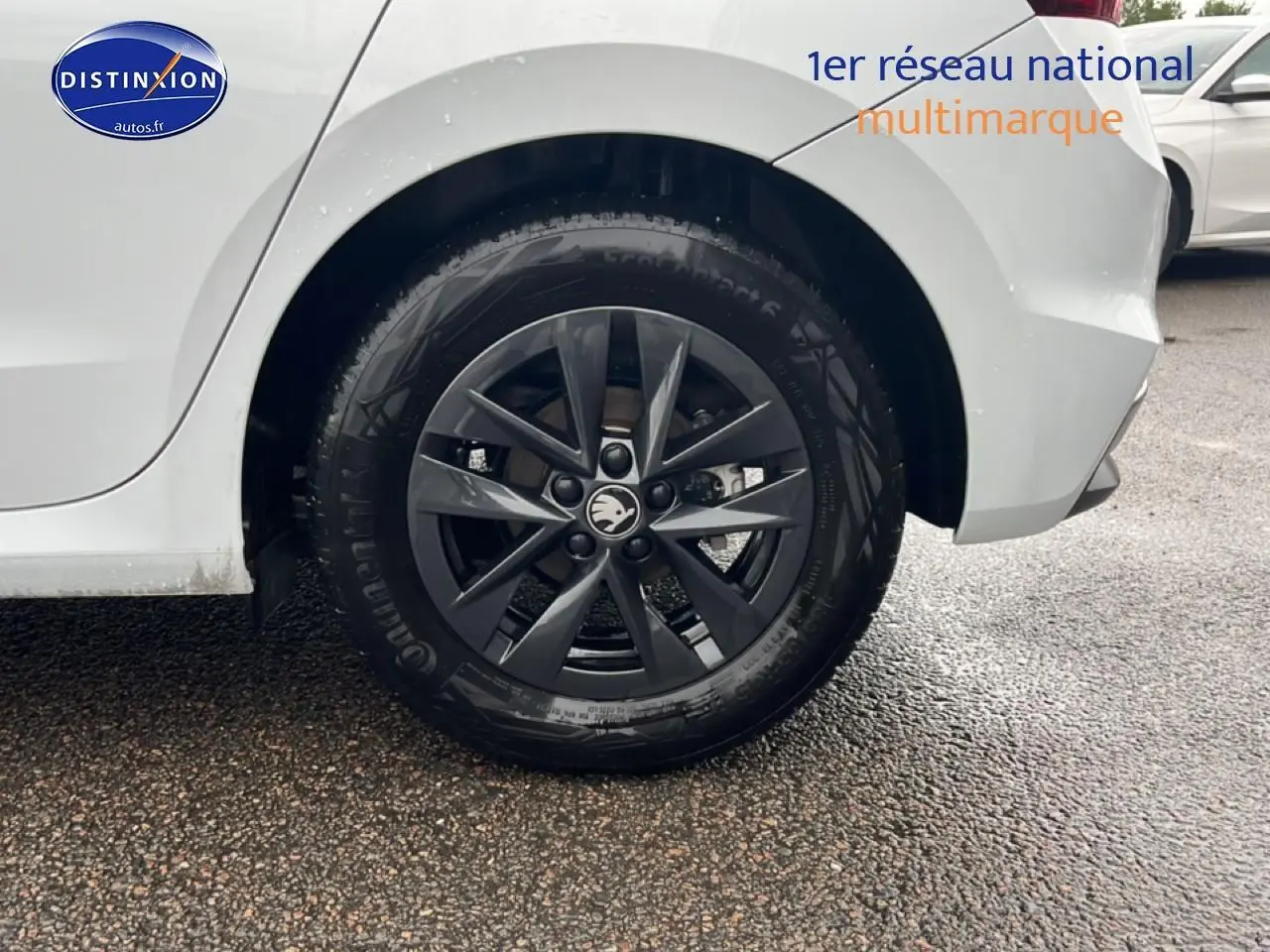 Gros plan sur la roue arrière droite d'une Skoda Fabia blanche avec jante alliage gris foncé.