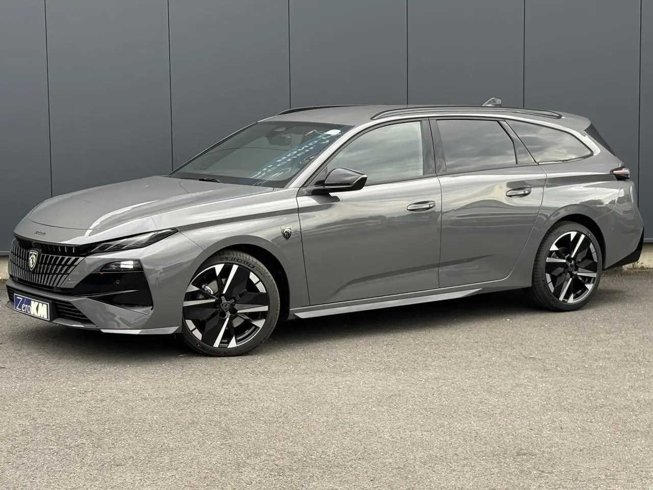 Peugeot 308 SW gris Sélénium vue de profil côté gauche, avec jantes alliage bi-tons et toit ouvrant.