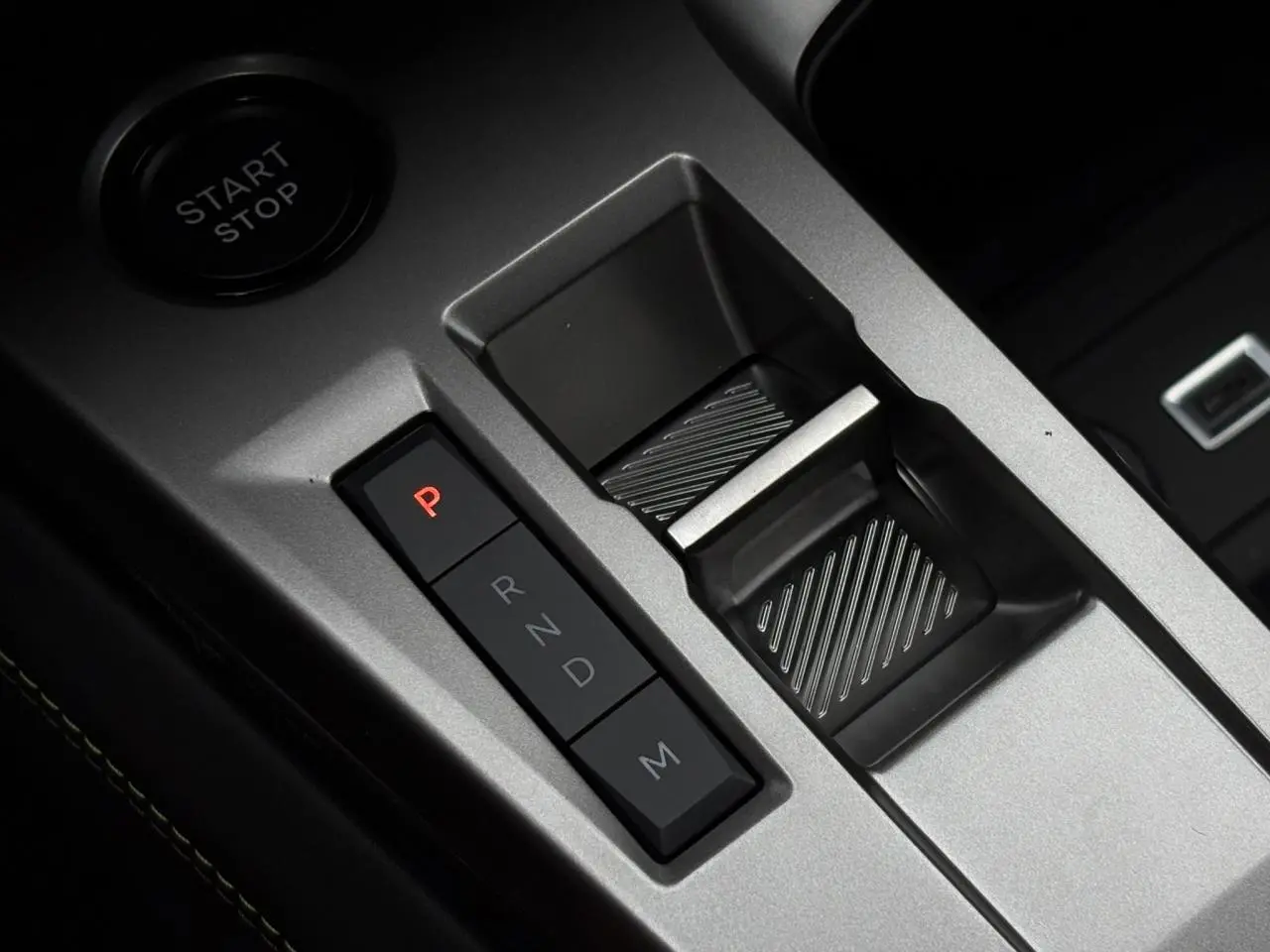 Gros plan sur la commande de boîte automatique et bouton start/stop du Peugeot 308 SW gris Sélénium, intérieur moderne.