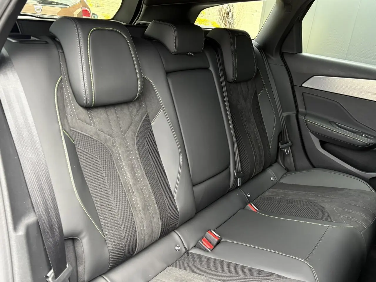 Vue intérieure côté droit des sièges arrière en Alcantara noir et cuir avec surpiqûres vert Adamite du Peugeot 308 SW 2026.