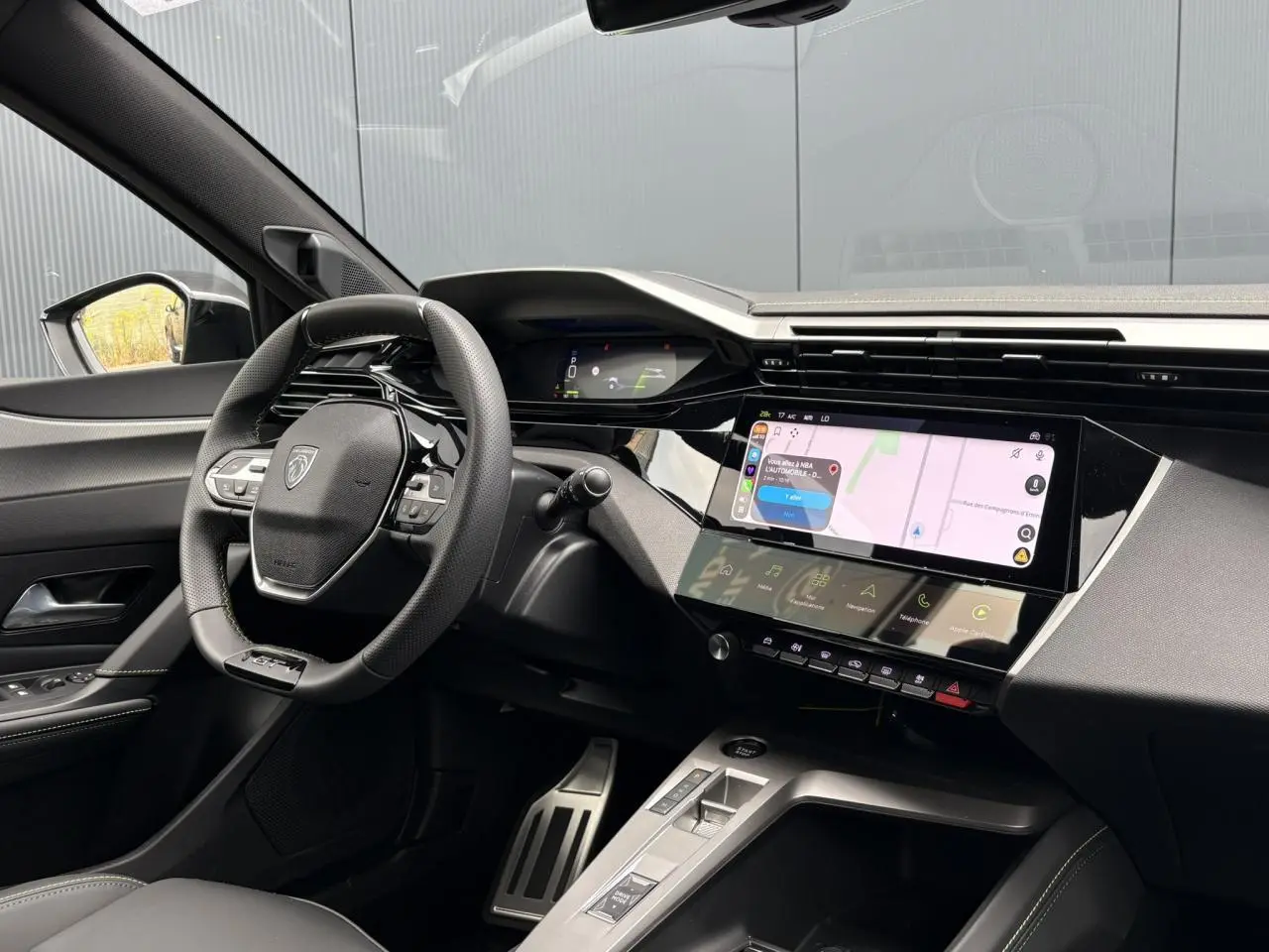 Vue intérieure côté conducteur du Peugeot 308 SW gris, volant compact GT, écran tactile et combiné numérique 3D.