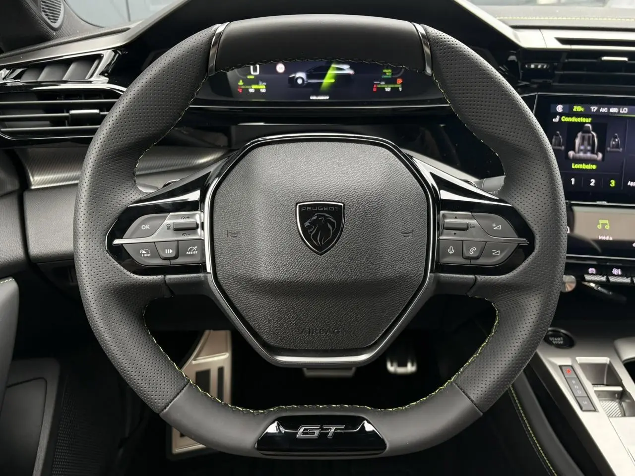 Vue rapprochée du volant GT en cuir noir avec surpiqûres vert Adamite du Peugeot 308 SW Hybrid 2026.