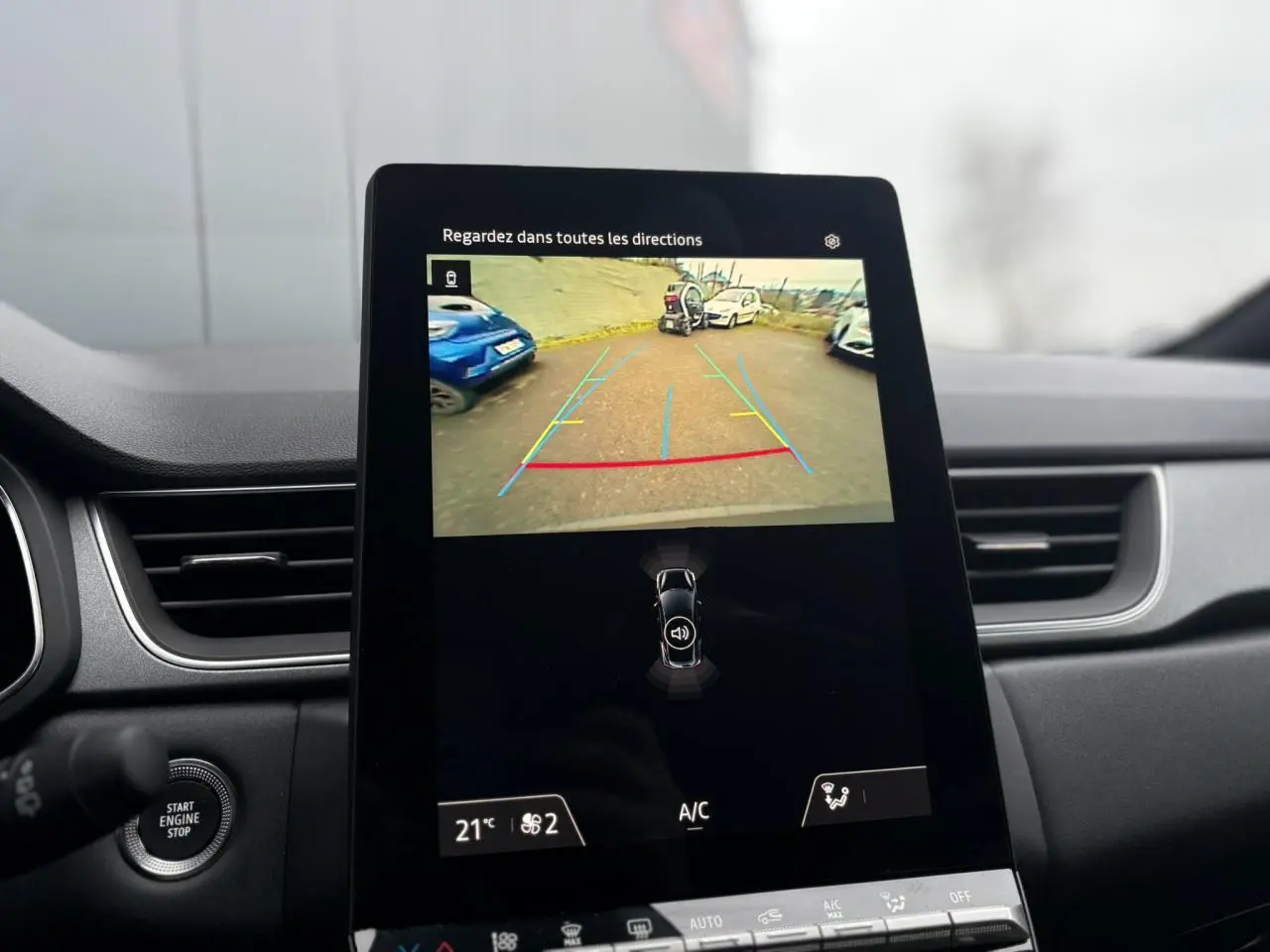 Écran central tactile montrant la caméra de recul du Renault Captur gris Cassiopée, intérieur avec tableau de bord noir.
