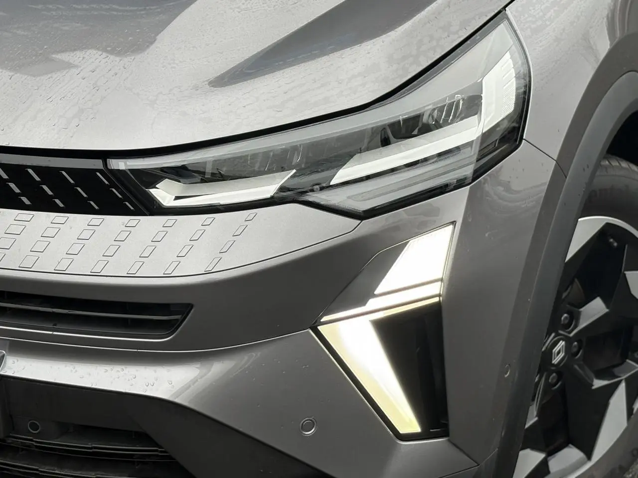 Gros plan sur l’avant droit du Renault Captur gris Cassiopée avec phares LED et jante alu noire diamantée.