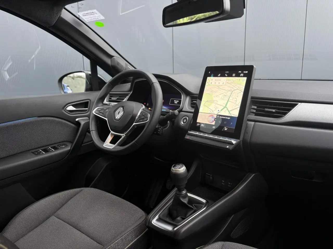 Vue intérieure côté conducteur du Renault Captur TCE 100 Techno 2025, avec tableau de bord numérique et écran tactile vertical.