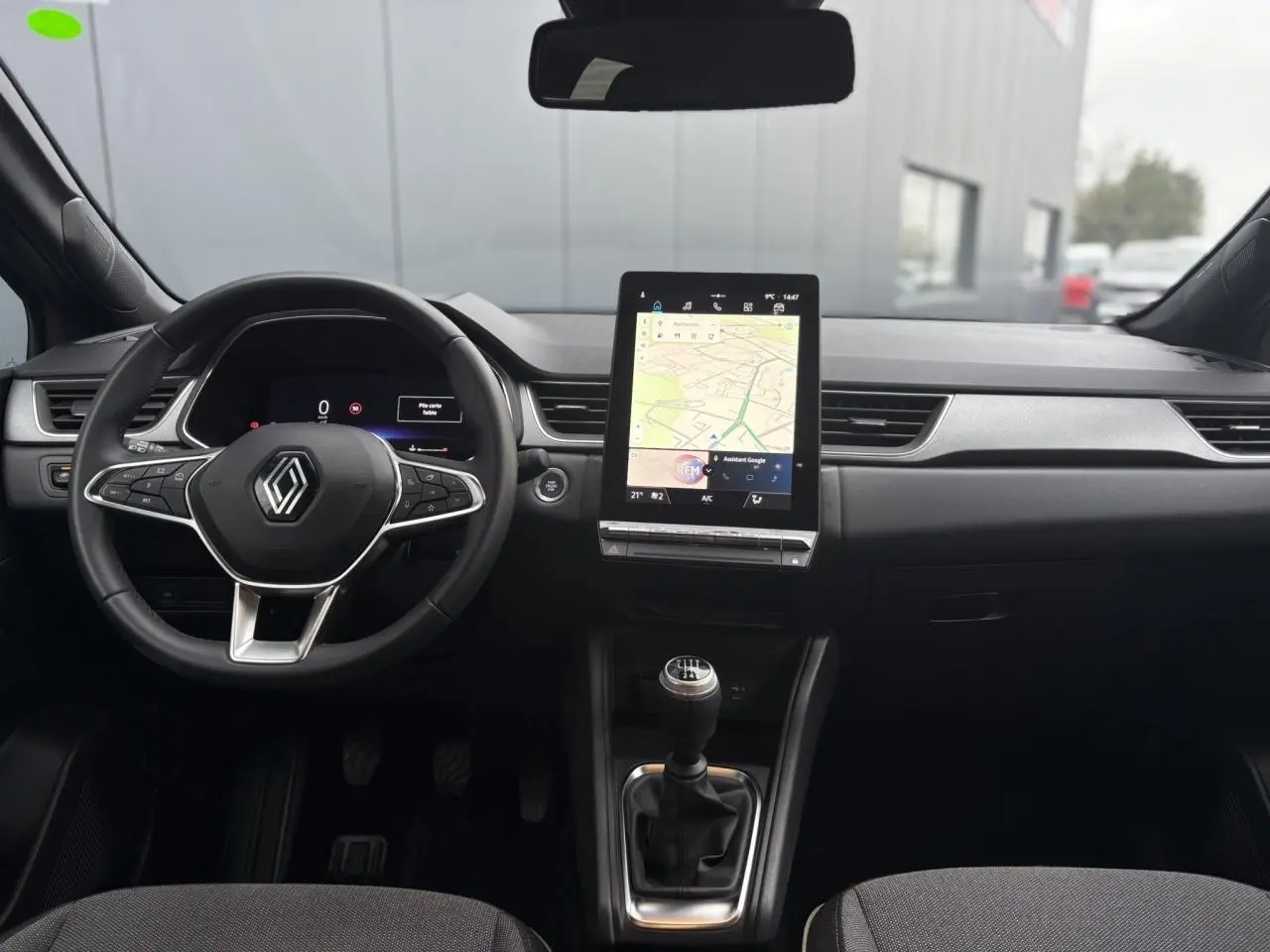Vue intérieure frontale du tableau de bord du Renault Captur TCE 100 Techno 2025 avec écran tactile vertical et boîte manuelle.